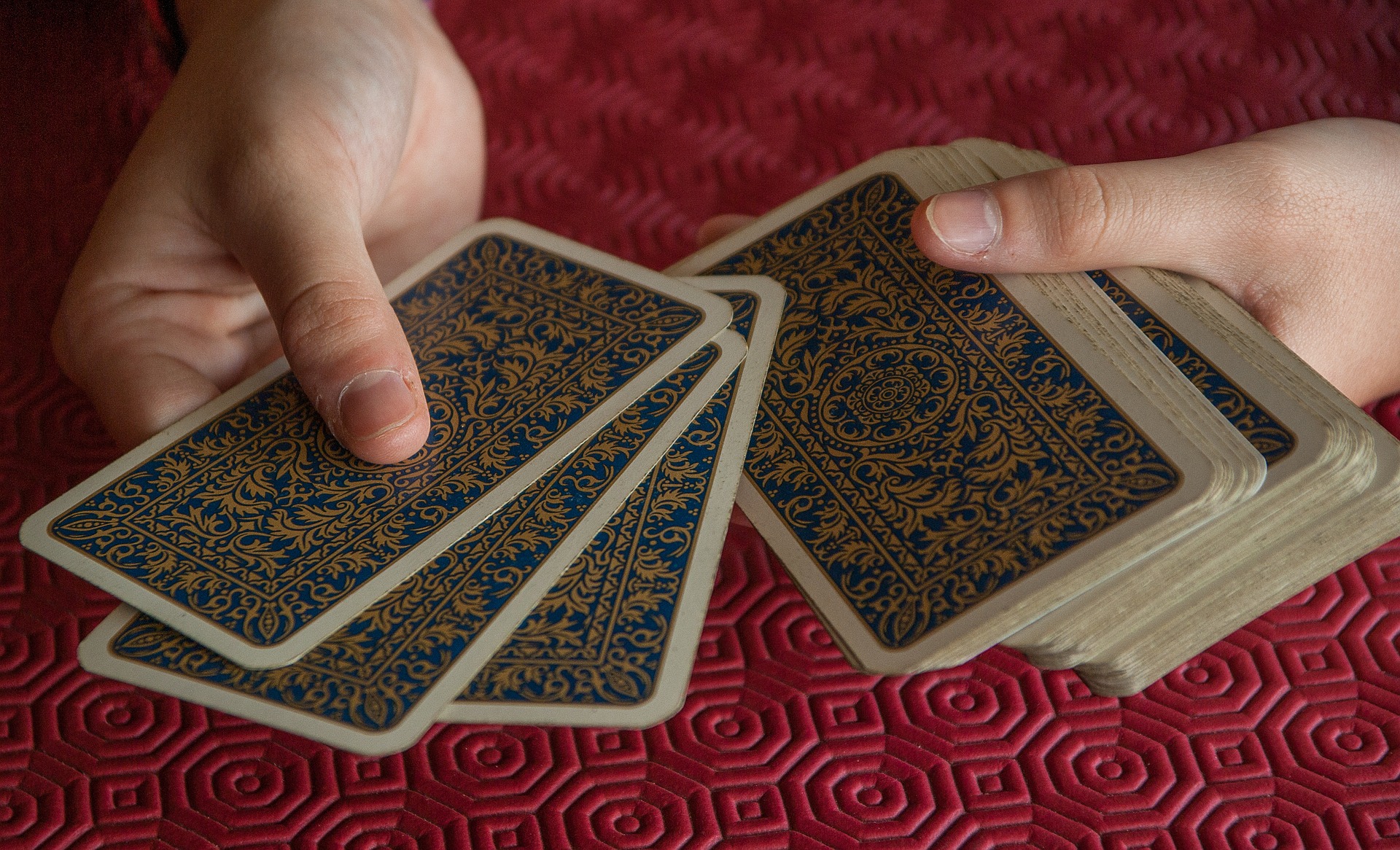 les mains distribuent les cartes sur un tapis rouge pour un travail de connaissance de soi